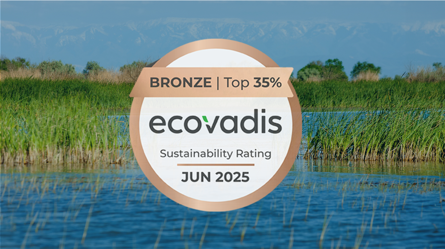 EcoVadis Sustainability Award logo over waterway with grassy vegetation.