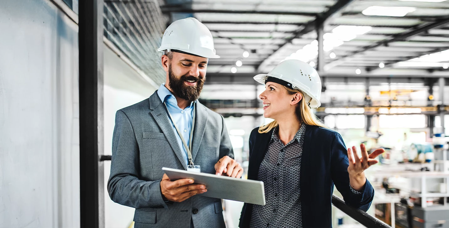 Businesspeople talking in manufacturing setting.
