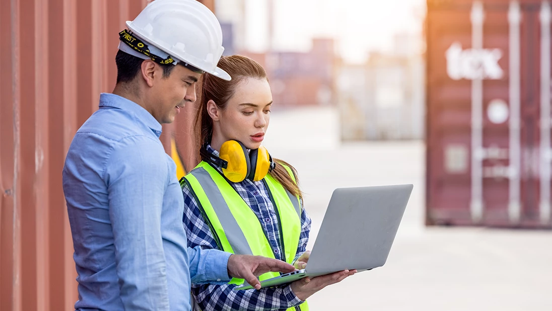 Woman and man shaking hands in a warehouse. 
