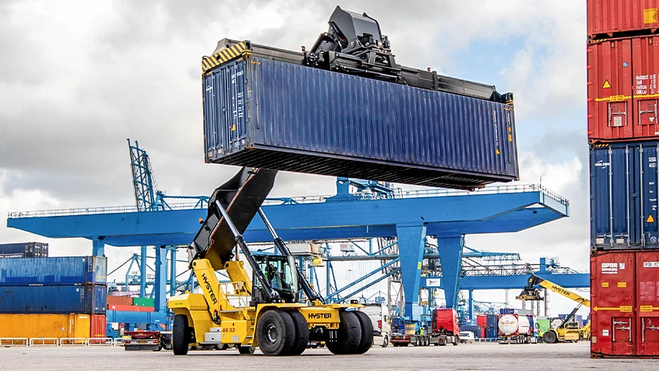 Hyster reach stacker transporting shipping container. 