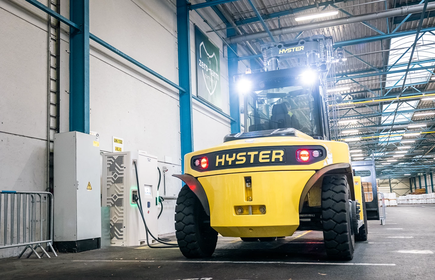 High-Capacity lithium-ion powered truck plugged into battery charging station.