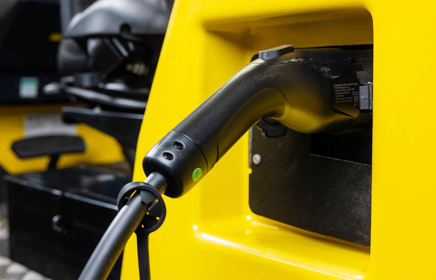 Close-up of a battery charging cable plugged into a Hyster lift truck.